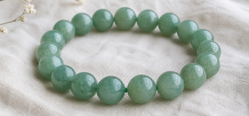 Green aventurine bead bracelet in soft daylight on linen